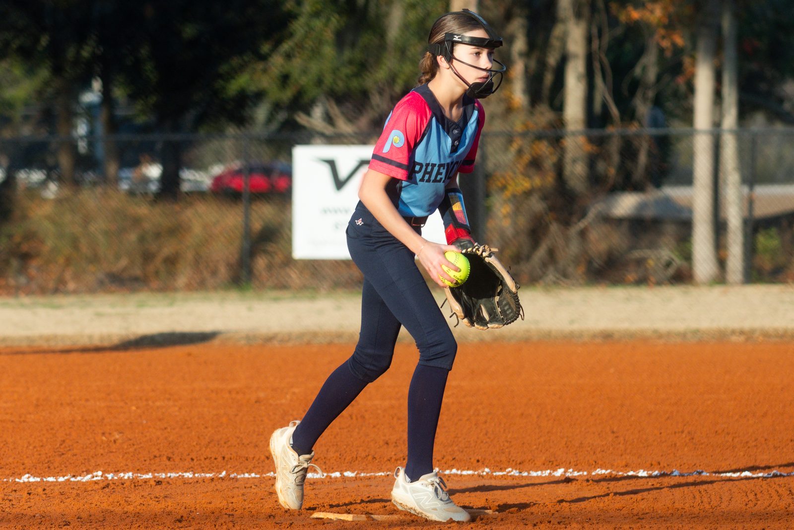 Camden set on the mound with the ball in her glove, reading the catcher