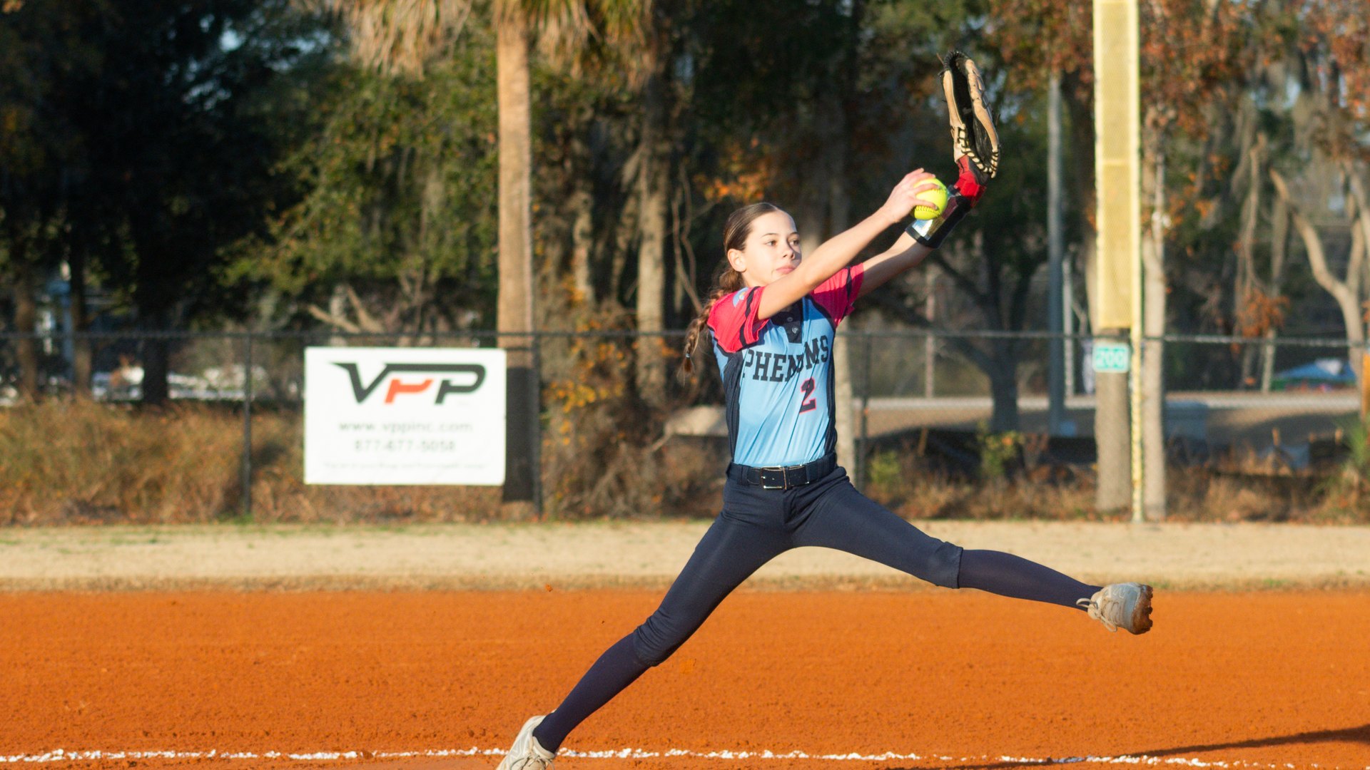 Camden Geary at full stride in her pitching windup, ball in hand